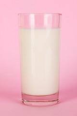 Glass of fresh new milk on pink background