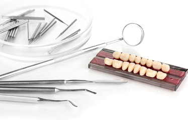 denture with dental tools isolated on white
