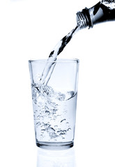 Pouring water into glass isolated on white