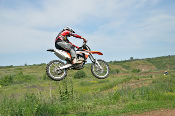 Motocross rider on a motorcycle in a jump