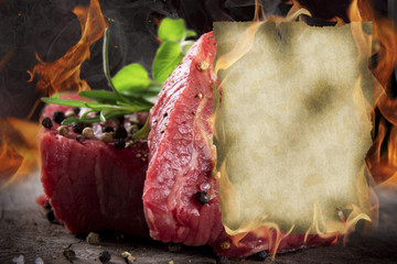 Raw beef steaks with burning blank paper