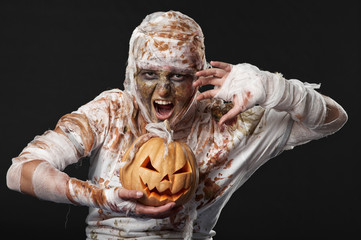 scary mummy waves her arms with pumpkin