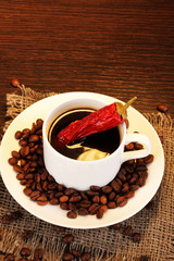 Coffee and pepper on wooden table on brown background