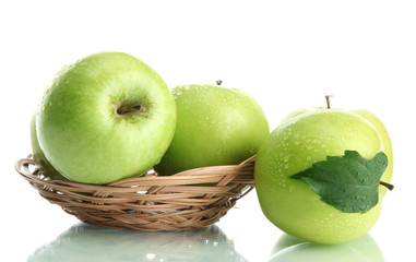 Ripe green apples with leaves in basket isolated on white