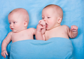 the twins, one licks a hand of another