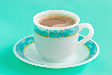 Cup of coffee on a green table.