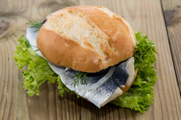 Fresh Herring on a roll (wooden background)