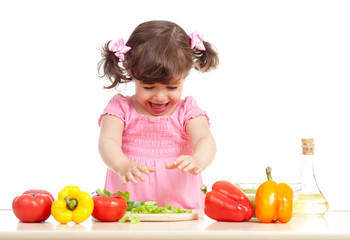 Little kid preparing vegetable salad. Concept of healthy food.