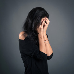 Woman close up portrait on dark background. Desperate expression