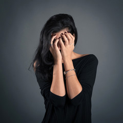 Woman close up portrait on dark background. Desperate expression