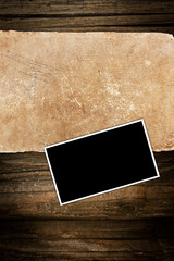Faded old paper and photo frame on wood