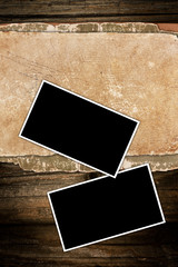 Aged paper and photo frames on wood