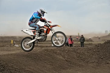 Foto op Canvas The motocross racer jumps by motorcycle © VVKSAM