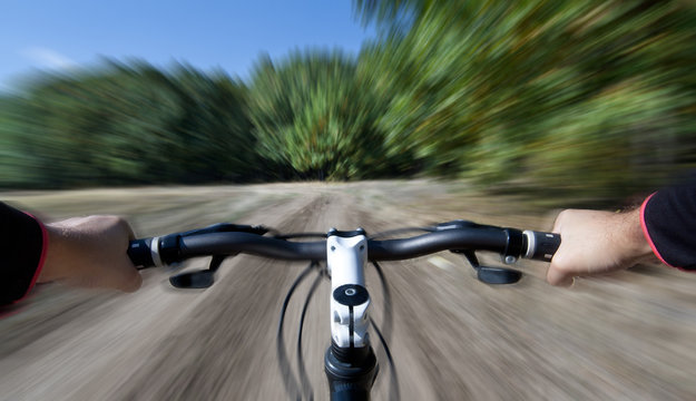 Mountain biking. View from bikers eyes. Motion blurred.