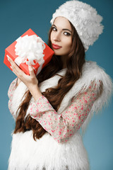 Beautiful girl with christmas gift in hand. Holidays concept