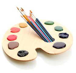 wooden art palette with  paint and brushes.isolated on white