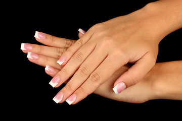 Beautiful woman's hands with french manicure on black