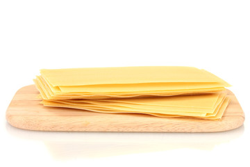 Uncooked lasagna pasta on cutting board isolated on white