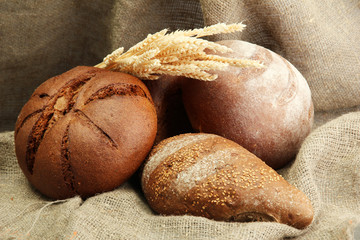 tasty rye breads with ears, on burlap background