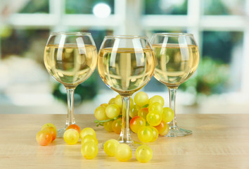 White wine in glass on window background