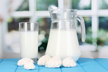 Pitcher and glass of milk with meringues