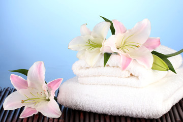 stack of towels with pink lily on blue background