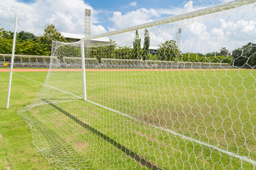 Soccer goal net in football field grass