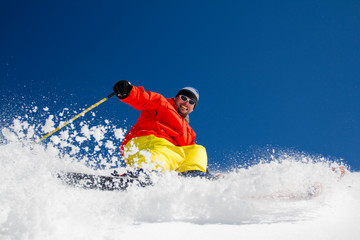 Freeride in fresh powder snow - man skiing downhill