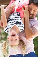 Father Holding Daughter Upside Down Outdoors