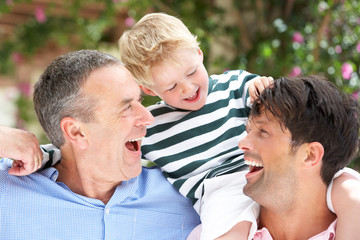 Fototapeta premium Grandfather And Father Giving Grandson Ride On Shoulders