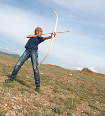 Boy shoots a bow at a target