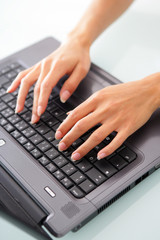 Fototapeta na wymiar Close-up of woman typing on a laptop