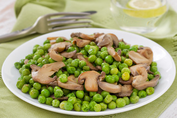 green peas with mushrooms with glass of water with lemon