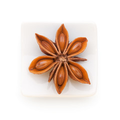 Anise star (Illicium verum)  in a white bowl on white background