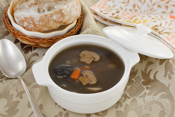 mushrooms soup in white bowl with bread