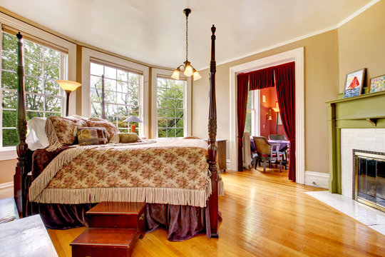 Large historical Inn room interior - bedroom with antique bed.
