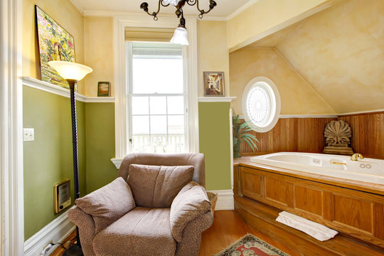 Historical Inn room interior - bathroom with tub and armchair.