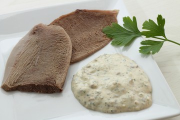 Slices of veal tongue with bagnet verd (parsley sauce)