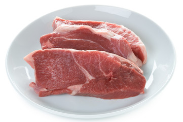 raw lamb leg steaks on a white plate isolated