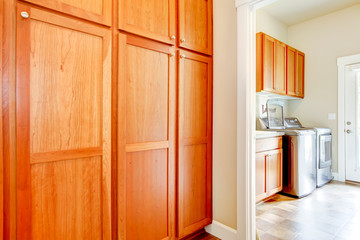 Laundry room with wood storage cabinets.