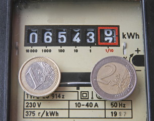 electricity meter with two coins of one and two euros
