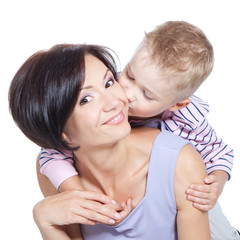 Closeup of cute little boy kissing beautiful mother over white