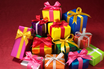 Pile of small gifts on red background.