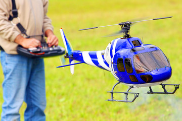 Piloting radio controlled helicopter with remote control.