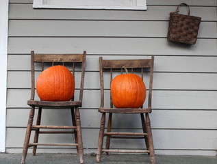 Old wood chairs and bright orange pumpkins