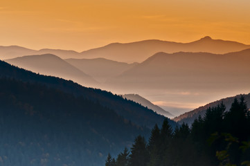 orange sunrise over the hazy autumn mountains