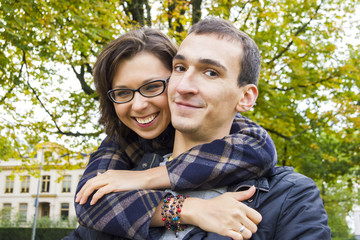Portrait of love couple embracing outdoor in park looking happy