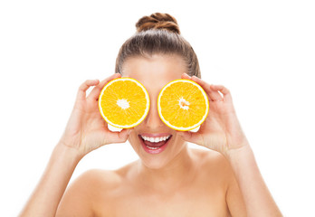 Woman holding oranges over eyes