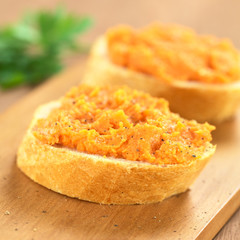Sweet potato spread on baguette slice with ground pepper