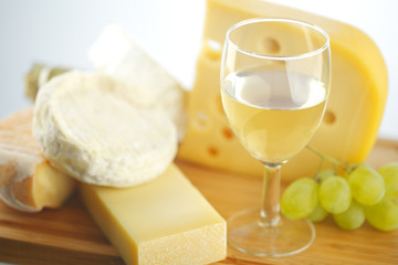 cheese and wine on a wooden table